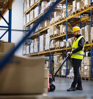 soldeur destockeur qui tire un transpalette rempli de cartons de produits d'une entreprise en liquidation