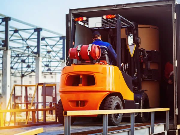 soldeur destockeur qui entre dans un camion sur un chariot élévateur 