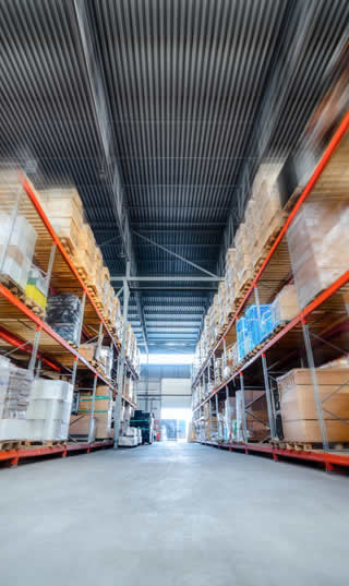 Grand hangar d'un entrepôt de destockage avec des étagères hautes pour le stock d'une entreprise en faillite